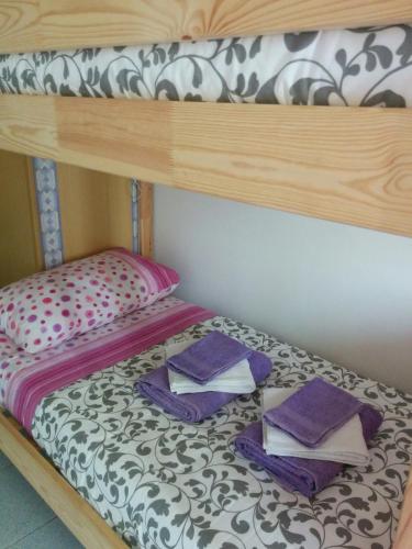 a bunk bed with towels on top of it at Casetta next to the Creek Dino Buzzati in Belluno