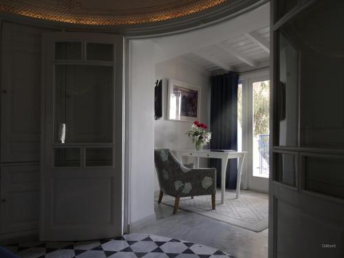 a living room with a chair and a table at La Villa Bleue-Sidi Bou Said in Sidi Bou Saïd