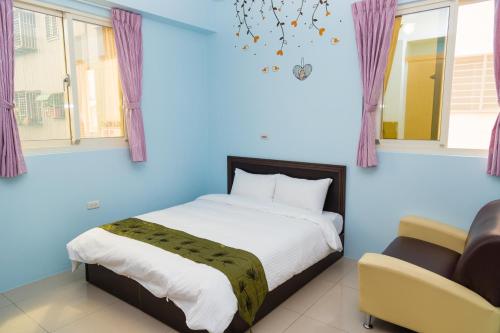a blue bedroom with a bed and a chair at Just Stay 稼軒 in Yuanshan