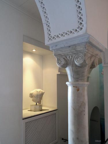 a statue sitting on a table in a museum at La Villa Bleue-Sidi Bou Said in Sidi Bou Saïd