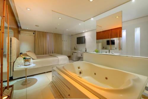 a large bathroom with a tub and a bedroom at Apple Motel ( Adults Only ) in Sao Paulo