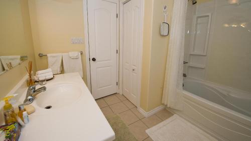 La salle de bains est pourvue d'un lavabo, d'une baignoire et d'une douche. dans l'établissement Tekdiv B&B, à Lansdowne
