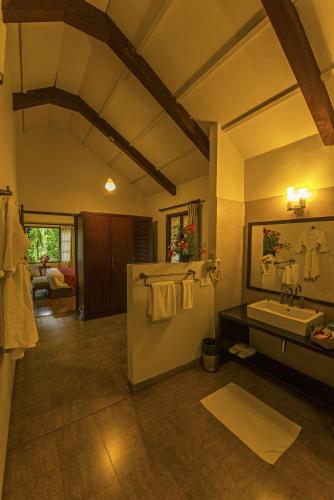 a large bathroom with a sink and a mirror at The Windflower Resort & Spa, Coorg in Suntikoppa