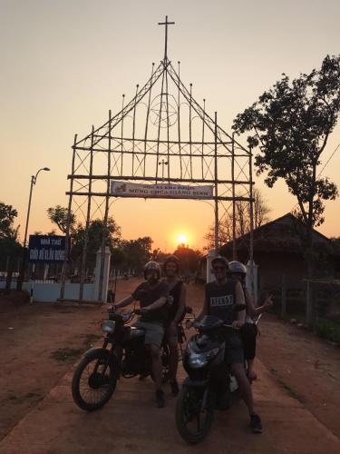 a group of people riding motorcycles in front of a metal structure at Vietnam Phuot Real Home in Kon Tum