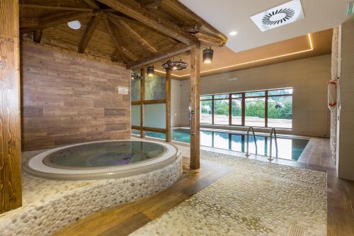 a jacuzzi tub in a room with a pool at Relax hotel Valaška in Horní Bečva