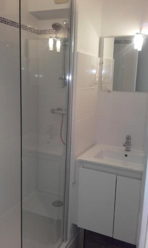une salle de bain blanche avec une douche et un lavabo dans l'établissement Residence Front De Mer, à Quiberon