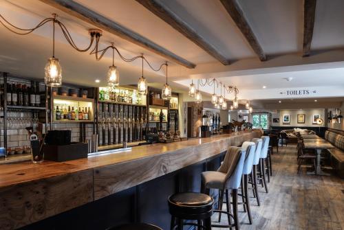 a bar with a wooden counter and bar stools at The Litton in Litton
