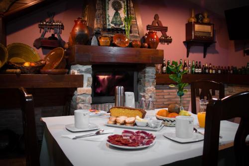 una mesa con comida y chimenea en Casa Rural Teresa, en Libros
