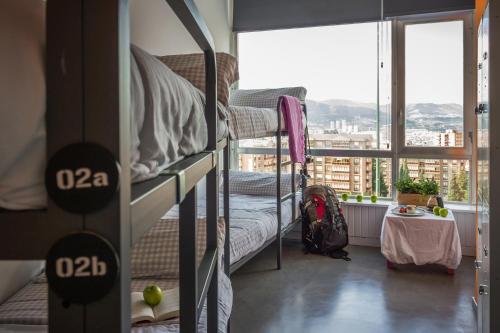 a dorm room with a balcony with bunk beds at All Iron Hostel in Bilbao