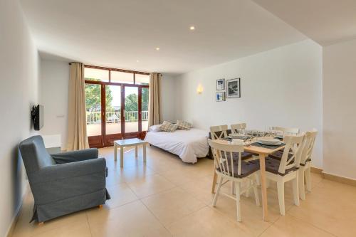 ein Wohnzimmer mit einem Esstisch und ein Schlafzimmer in der Unterkunft Bagari Apartments Camp de Mar in Camp de Mar