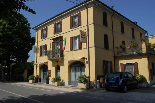 un edificio amarillo con un coche aparcado delante de él en B&B Sant'Antonio, en Gramignazzo