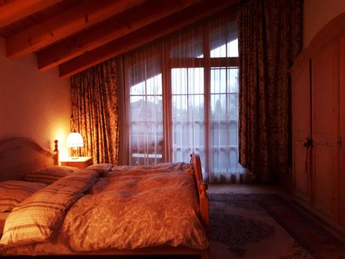 a bedroom with a bed and a large window at Haus Erika in Oberreute