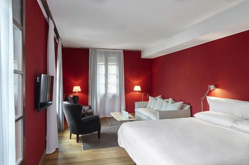 a hotel room with a white bed and a red wall at Casa Camper Barcelona in Barcelona