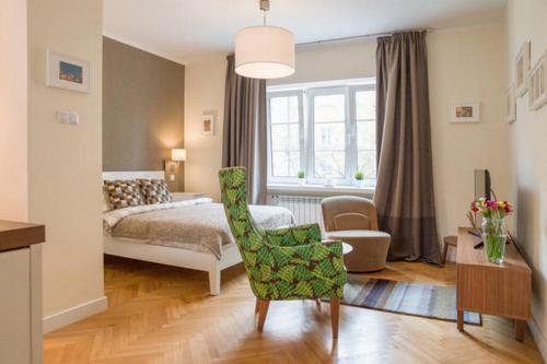 a bedroom with a bed and a chair and a table at Old Town Warsaw Joanna's Apartments in Warsaw