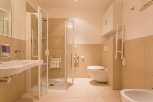 a bathroom with a shower and a toilet and a sink at Wally Residence in Rimini