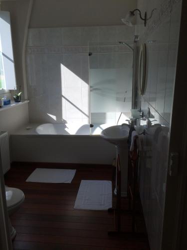 une salle de bain avec une baignoire, un lavabo et des toilettes dans l'établissement Le Clos Boutenelle, à Éperlecques