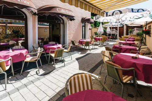 a restaurant with tables and chairs with pink tables at Hotel garni Fuchs in Eichstätt
