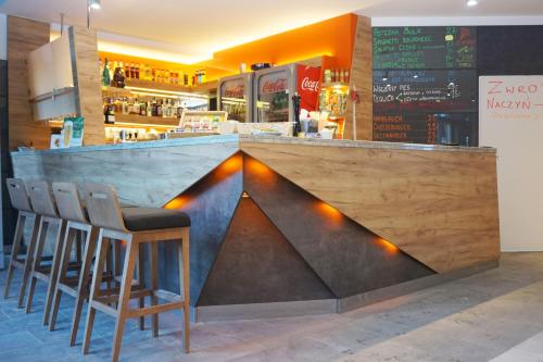 a bar in a restaurant with chairs around it at Villa Winterpol in Karpacz