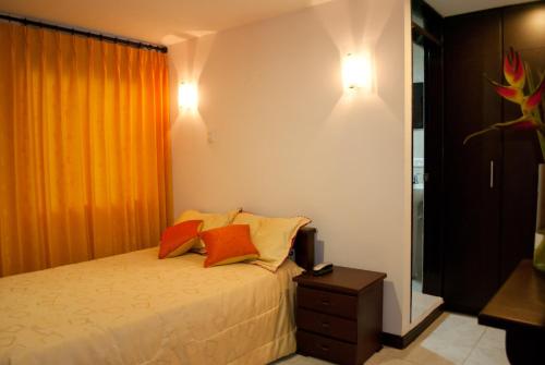 a bedroom with a bed with two pillows on it at Hotel Royal Suite in Manizales