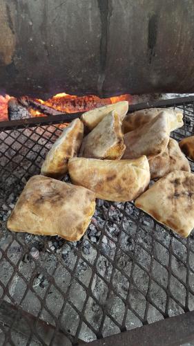 a bunch of food cooking on a grill at The Riverdeck Accommodation and Backpackers in Knysna