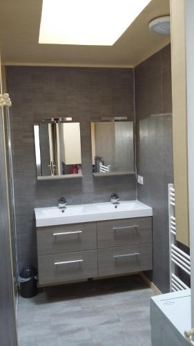 uma casa de banho com dois lavatórios e dois espelhos em Gite La Chouette em Bégard