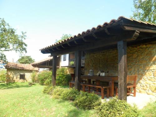 a stone house with a wooden table in front of it at Casa Rural La Retuerta in Nava