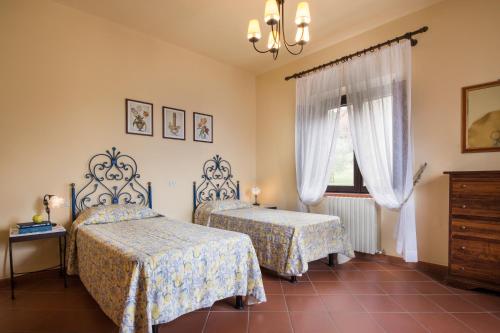 a bedroom with two beds and a window at Casa Vacanze Villa il Castellaccio in Lucolena in Chianti