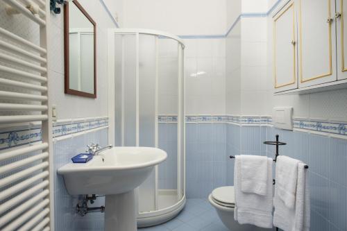 Baño blanco con lavabo y aseo en Casa Vacanze Villa il Castellaccio, en Lucolena in Chianti