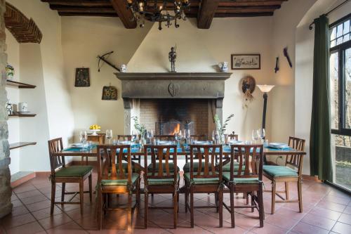 a dining room with a table and chairs and a fireplace at Casa Vacanze Villa il Castellaccio in Lucolena in Chianti