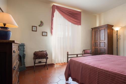 a bedroom with a bed and a dresser and a window at Casa Vacanze Villa il Castellaccio in Lucolena in Chianti