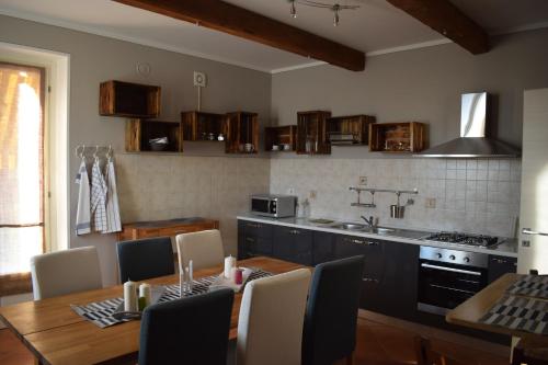 a kitchen with a dining table and a kitchen with a stove at Bene&Breakfast in Bene Vagienna