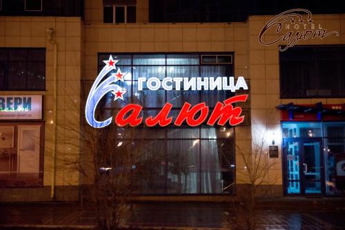a neonatalatalatal calzone sign on a building at night at Salute Hotel in Belgorod