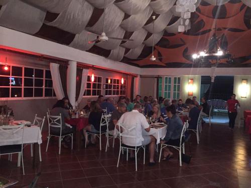 a group of people sitting at tables in a restaurant at Hotel Rey in Concepción de La Vega