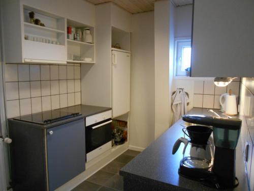 a small kitchen with a black counter top at Marskferie Tønder in Tønder