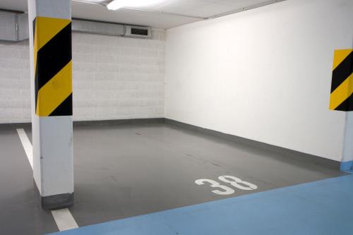 an empty parking garage with a parking sign on the floor at Coimbra Vintage Lofts Apartments in Coimbra