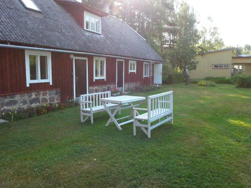 a picnic table and two benches in front of a house at Kuus Tuba in Leisi