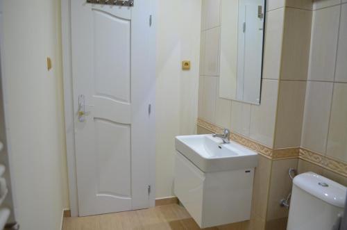 ein weißes Bad mit einem Waschbecken und einem WC in der Unterkunft Apartmány u Barči in Franzensbad