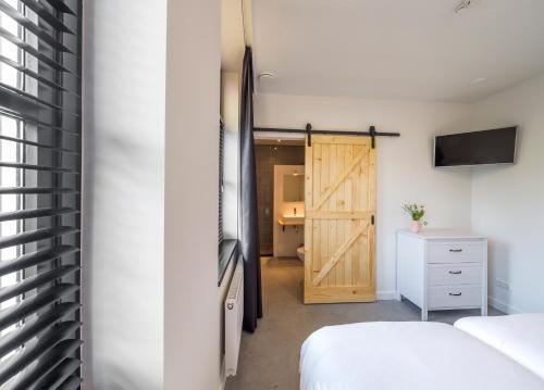 a bedroom with a sliding barn door and a bed at Bij Jans in Hilvarenbeek