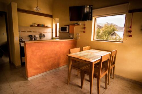 cocina con mesa de madera y ventana en Latitud 49 Apart en El Chaltén
