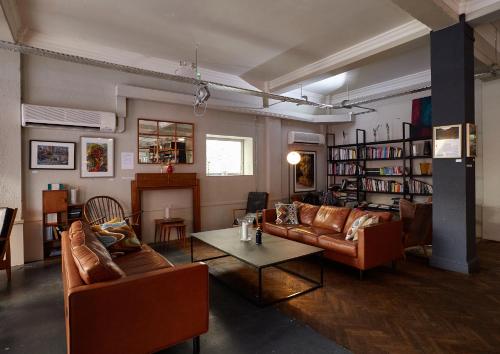 a living room with leather couches and a table at Green Rooms in London