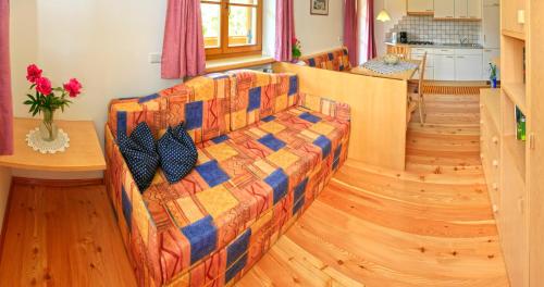 a living room with a couch and a kitchen at App Unterhoezlhof in Valdaora