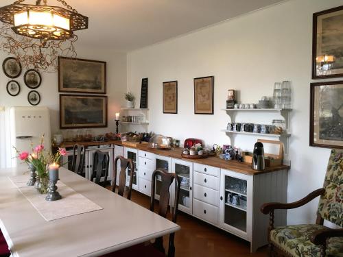 a kitchen with a table and a dining room at Bed & Breakfast Vragerups Gård in Lomma