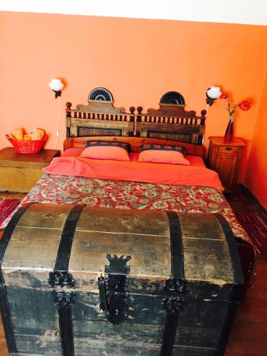 a bedroom with a bed with an old trunk at Baltā māja in Pilsrundāle