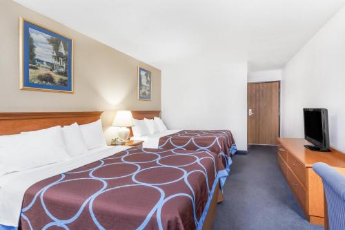 a hotel room with a large bed and a tv at Super 8 by Wyndham Montgomery Maybrook in Montgomery