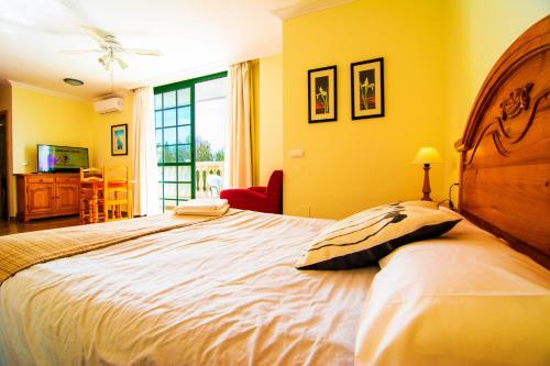 ロケタス・デ・マルにあるRoquetas Beach and Playa Serena Golf Villageのベッドルーム1室(黄色い壁の大型ベッド1台付)