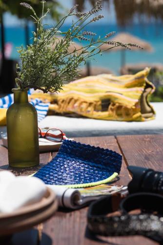 a wooden table with a vase of flowers and a vase of scissors at Golden Beach Hotel in Chrissi Akti