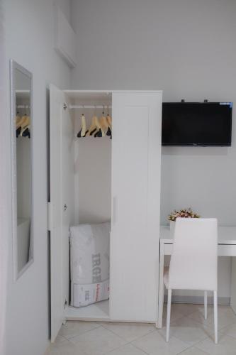 a white room with a desk and a table and a tv at B&B Lamezia Airport in Lamezia Terme
