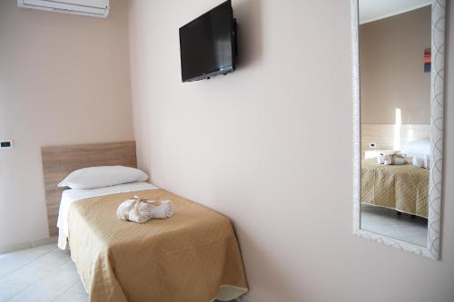 a bedroom with a bed with a mirror and a television at B&B Lamezia Airport in Lamezia Terme