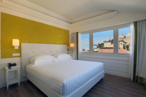 a bedroom with a large white bed and a window at Grand Hotel Palace in Ancona