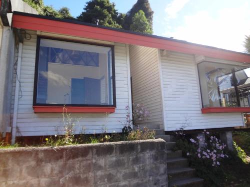 a house with a window on the side of it at Cabañas del Puerto in Puerto Montt